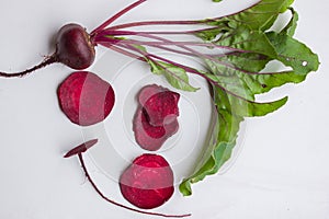 Fresh beetroots with leaves on white table.Whole and cut beetroots