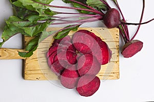 Fresh beetroots with leaves on wood table.Whole and cut beetroots