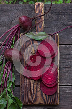 Fresh beetroots with leaves on wood table.Whole and cut beetroots