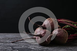 Fresh beets on grey table against black background. Space