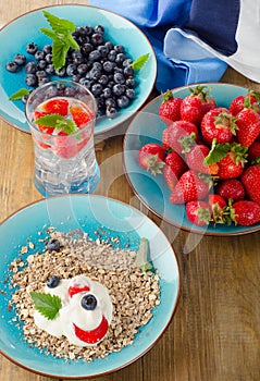 Fresh berries drink and muesli on wooden table.