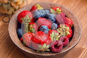 Fresh berries , strawberries, raspberries, blueberries in a copper bowl