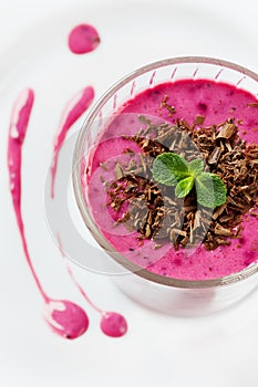 Fresh berry smoothie, milkshake, yogurt, dessert decorated grated chocolate and mint