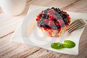 Fresh berry tartlet or cake filled with custard, raspberry, blueberry redcurrant and blackberry delicious dessert, easy