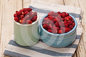 Fresh bilberries and strawberries in blue bowls, healthy eating concept