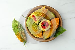 Fresh bitter melons on white marble table, flat lay