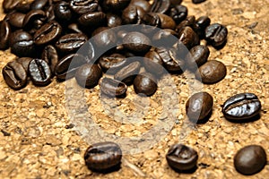 Fresh black coffe beans on cork table