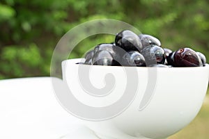 Fresh black grapes and leaf on the white table