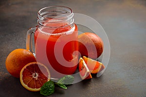 Fresh blood orange juice in jar on dark background.