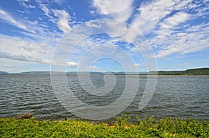 Fresh blue sky and bright white clouds over the mountains and the lake