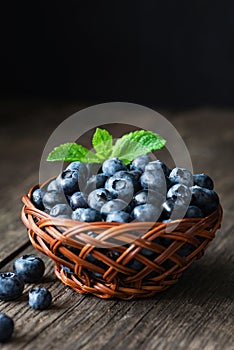 Fresh blueberries in a basket on wooden table