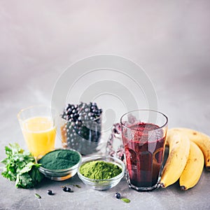 Fresh blueberries, bilberry, barley grass juice, spirulina, orange juice, dulse and cilantro on marble background. Heavy metals