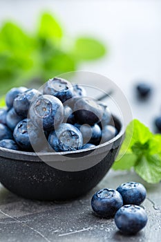 Fresh Blueberries in a bowl on dark background, top view. Juicy wild forest berries, bilberries.