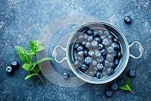Fresh Blueberries in a bowl on dark background, top view. Juicy wild forest berries, bilberries