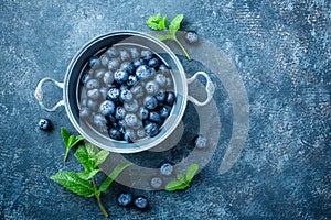 Fresh Blueberries in a bowl on dark background, top view. Juicy wild forest berries, bilberries