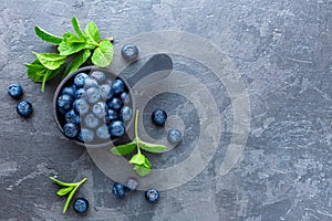 Fresh Blueberries in a bowl on dark background, top view. Juicy wild forest berries, bilberries