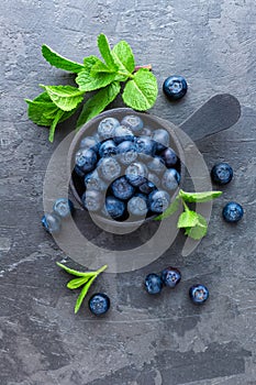 Fresh Blueberries in a bowl on dark background, top view. Juicy wild forest berries, bilberries