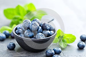 Fresh Blueberries in a bowl on dark background, top view. Juicy wild forest berries, bilberries.