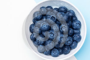 Fresh blueberries in bowl isolated on white. Top view.