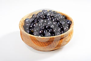 Fresh blueberries in a wooden bowl on white