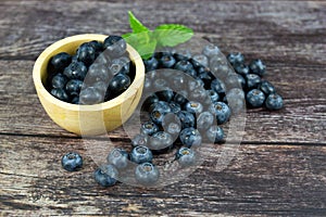 Fresh blueberries in a wooden bowl on wood table