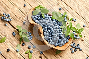 Fresh blueberries in wooden dish on planks background