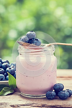 Fresh blueberries yogurt in glass jar.