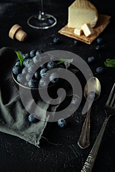 Fresh blueberry bowl with cheese and wine.