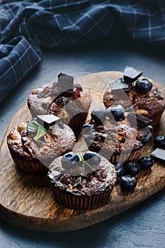 Fresh, blueberry muffins on a stone background with sugar and fruits. Food background. Concept of pastry.