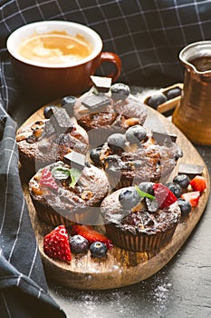 Fresh, blueberry muffins on a stone background with sugar and fruits. Food background. Concept of pastry.