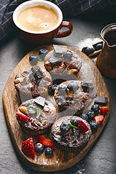 Fresh, blueberry muffins on a stone background with sugar and fruits. Food background. Concept of pastry.