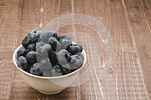 fresh blueberry in a white bowl/ fresh blueberry in a white bowl on a wooden background. Copy space