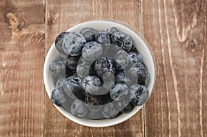 fresh blueberry in a white bowl/fresh blueberry in a white bowl on a wooden background. Top view