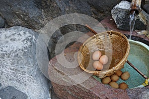 Fresh boiled eggs with natural mineral hot water in woven basket