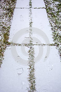 Fresh bootprints in the snow. The first snow on the path. Beginning of winter photo