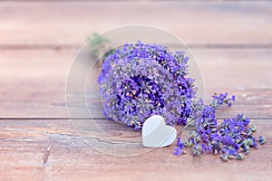 Fresh bouquet of lavender and a heart on brown wooden background