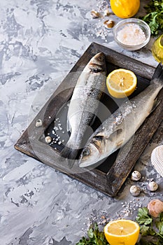 Fresh branzino fish with parsley, lemon and pink Himalayan salt