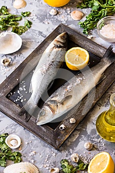 Fresh branzino fish with parsley, lemon and pink Himalayan salt