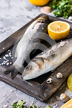 Fresh branzino fish with parsley, lemon and pink Himalayan salt