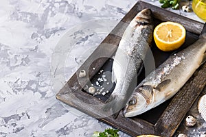 Fresh branzino fish with parsley, lemon and pink Himalayan salt