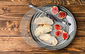 Fresh bread with butter and ripe figs on metal tray