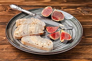 Fresh bread with butter and ripe figs on metal tray