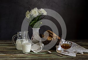The fresh bread, honey and milk and a vase with white daisies