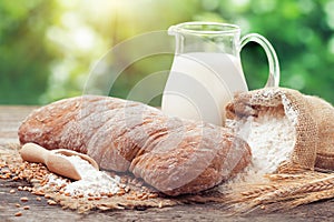 Fresh bread, jug of milk, sack of flour and wheat ears