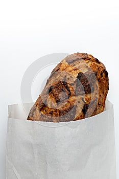 Fresh bread in paper bag isolated on white background, top view
