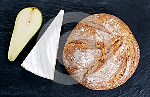 Fresh Bread with Pear and cheese on old blue stone background.