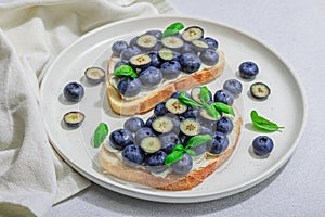 Fresh bread sandwiches with sweet blueberries, cream cheese and basil leaves. Good morning concept