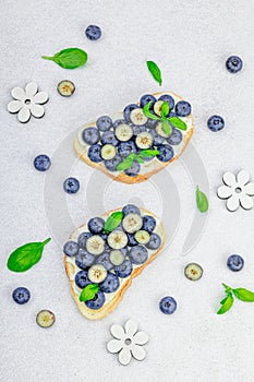 Fresh bread sandwiches with sweet blueberries, cream cheese and basil leaves. Good morning concept