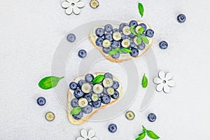 Fresh bread sandwiches with sweet blueberries, cream cheese and basil leaves. Good morning concept