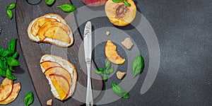 Fresh bread sandwiches with sweet peach slices, cream cheese and basil leaves. Good morning concept